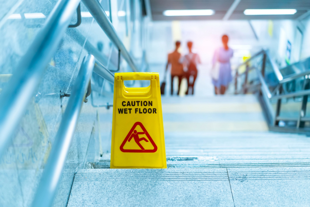 Caution Wet Floor sign on stairs from above, ensuring safety.