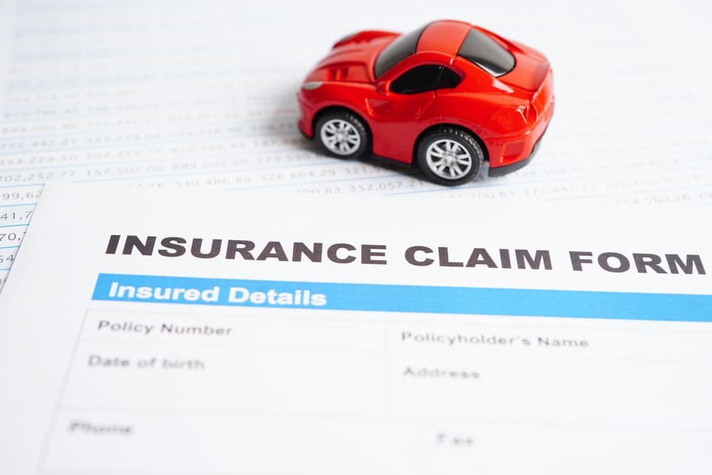 A stethoscope rests on an insurance claim form for a car accident, symbolizing car loan, insurance, and leasing time concepts.






