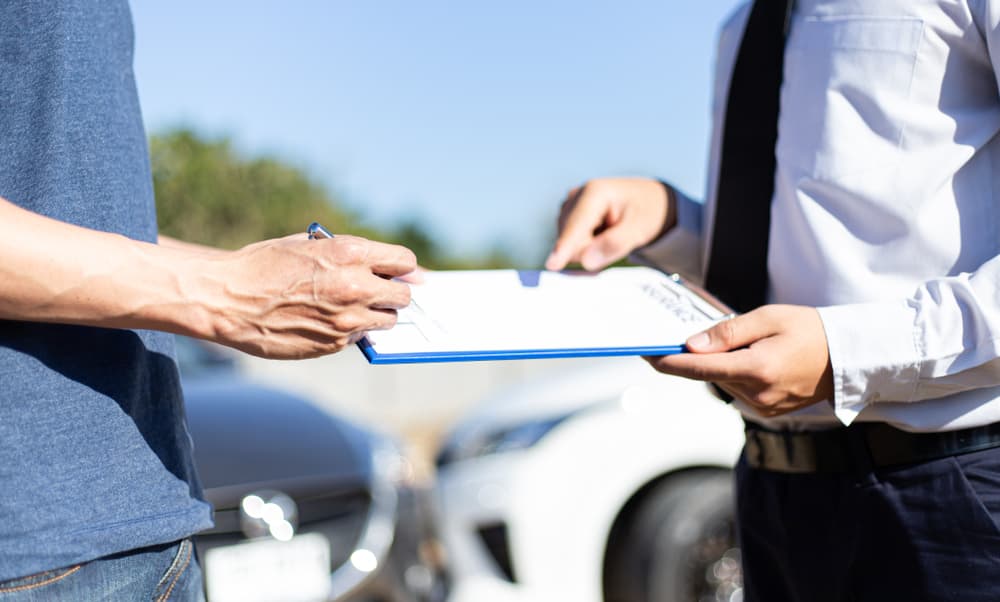 Customers and car insurance agents have entered into agreements and signed documents to claim compensation after a car accident, highlighting the insurance concept.