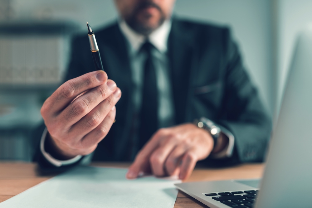 lawyer offering pen for client to put signature on agreement,