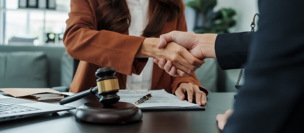 Shaking hands,female lawyer people earn dollars after winning a lawsuit.