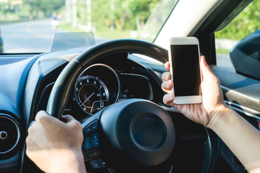 Man driver using smart phone in car