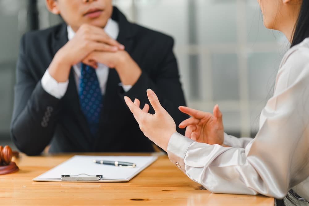 A person consulting with a lawyer, discussing important legal documents and time limits for their case.